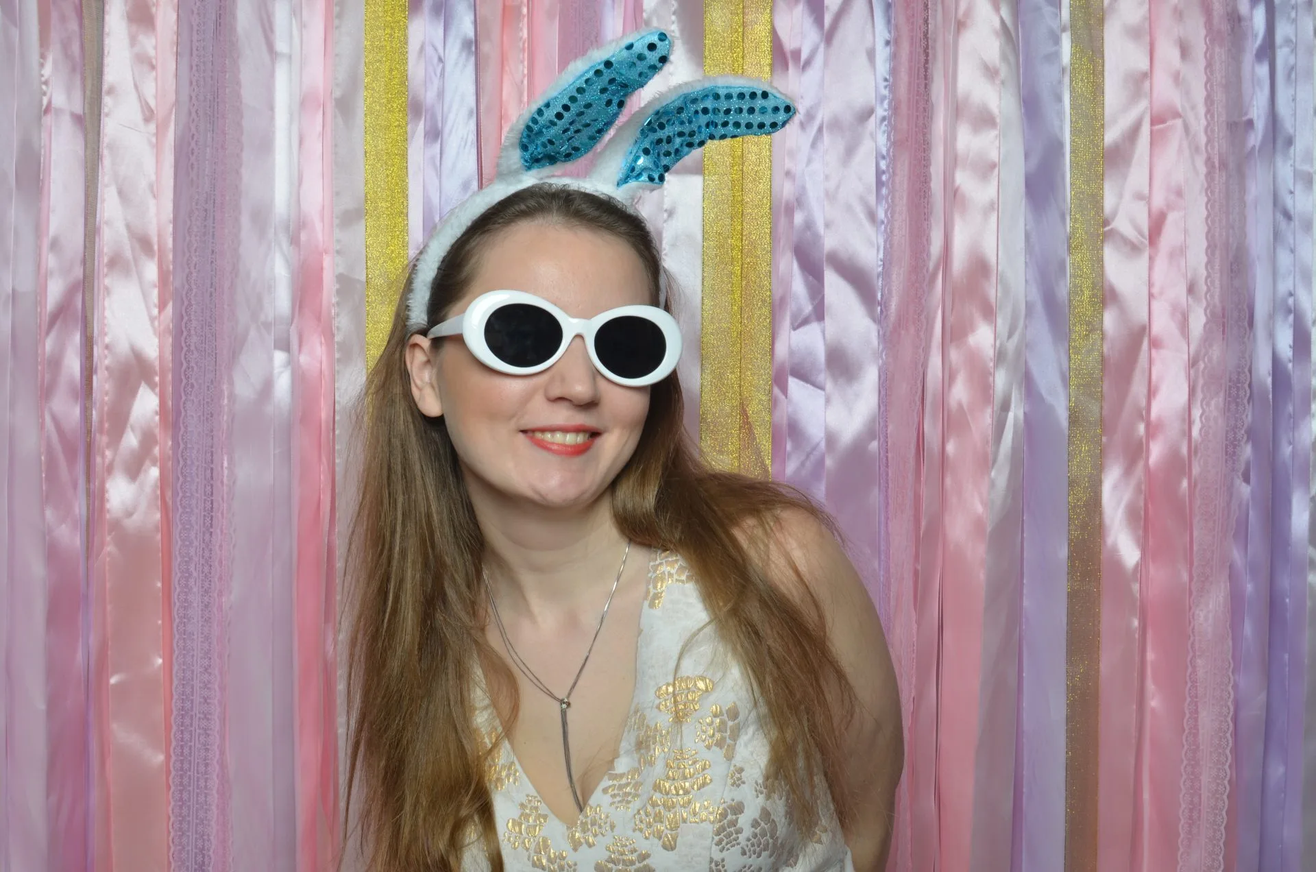 Праздничная фотография девушки в очках на радужном фоне с ушками